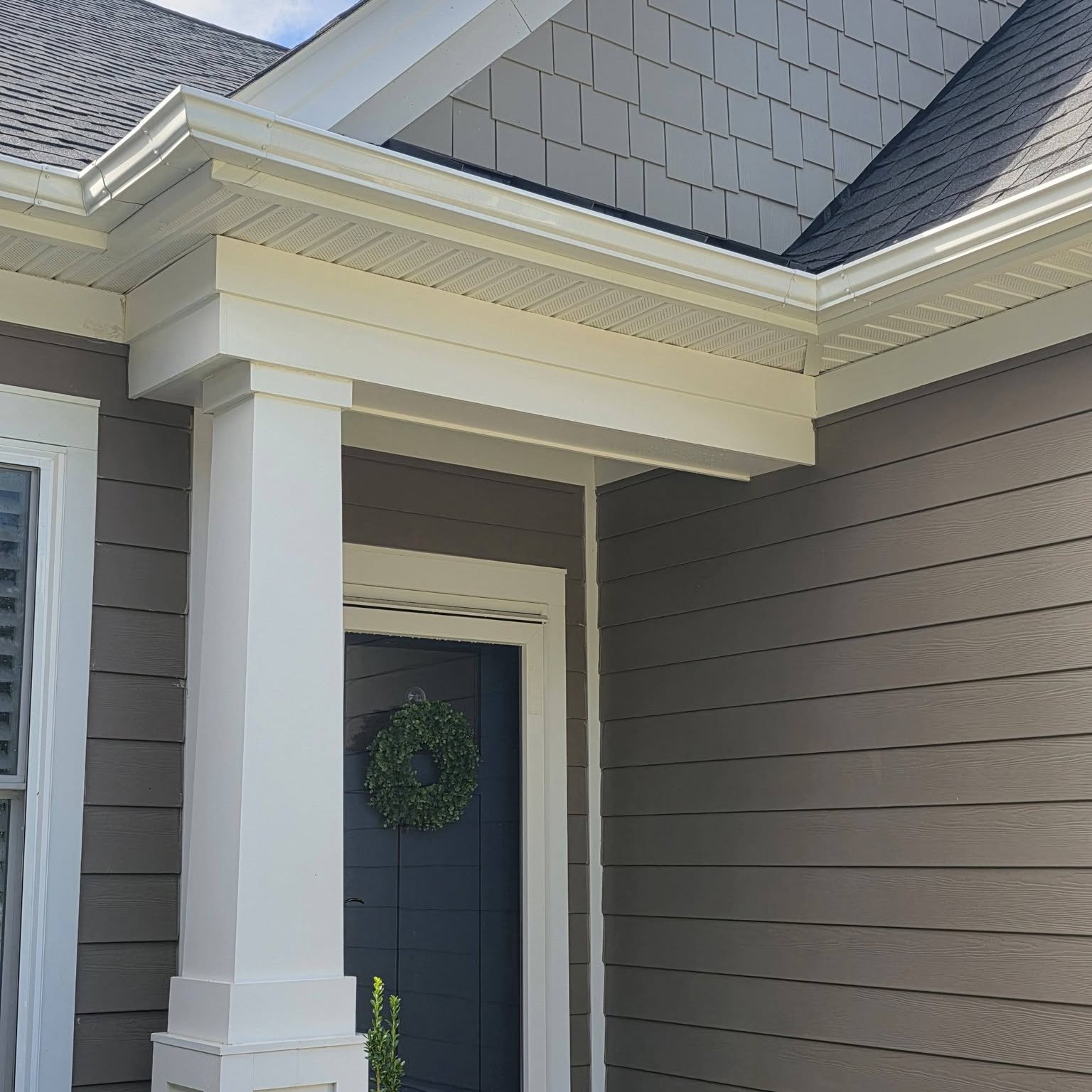 Gutters and soffit brightened after cleaning on a Radford home