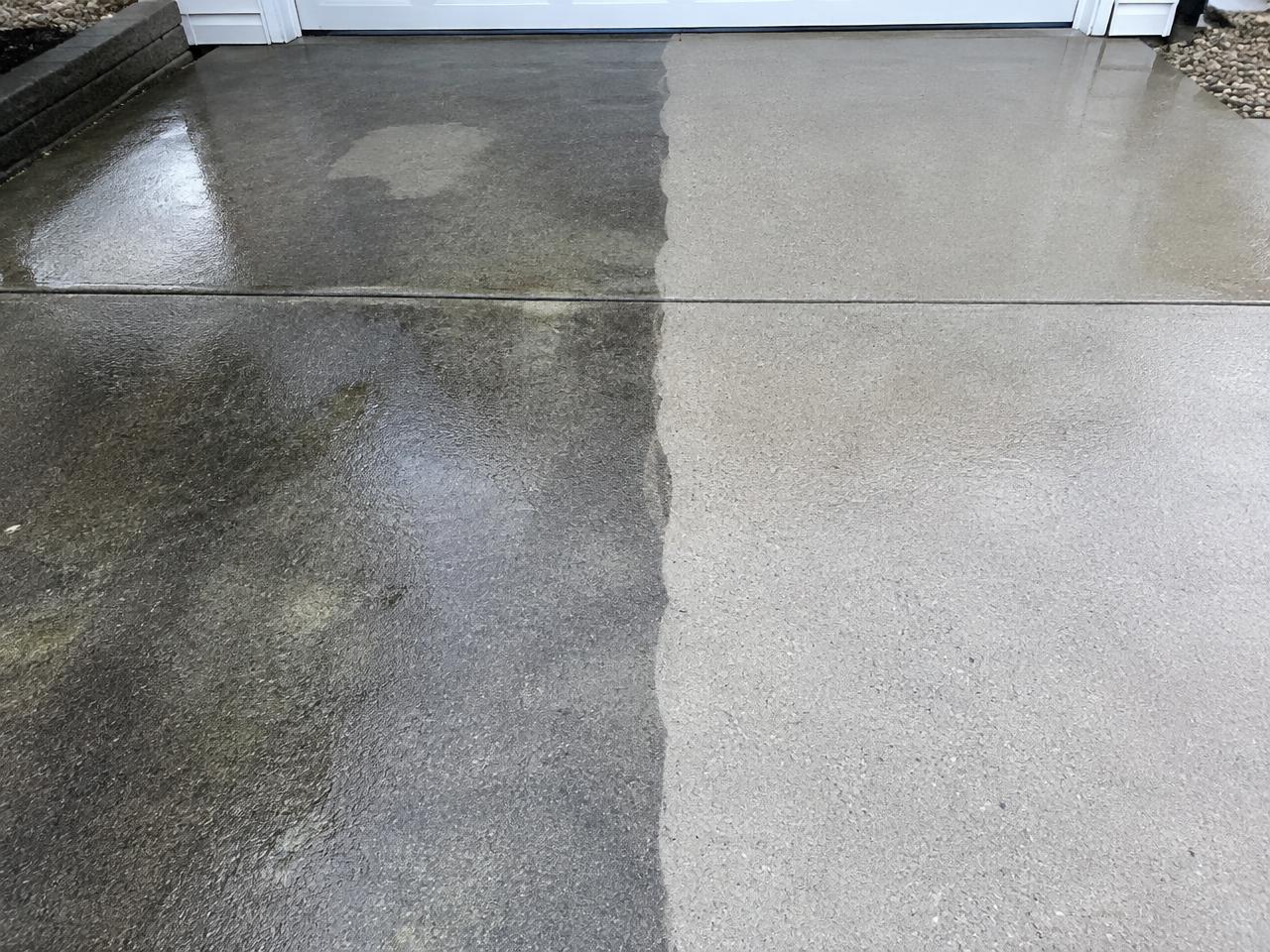 Concrete driveway half cleaned by pressure washing, dirty on one side and bright on the other