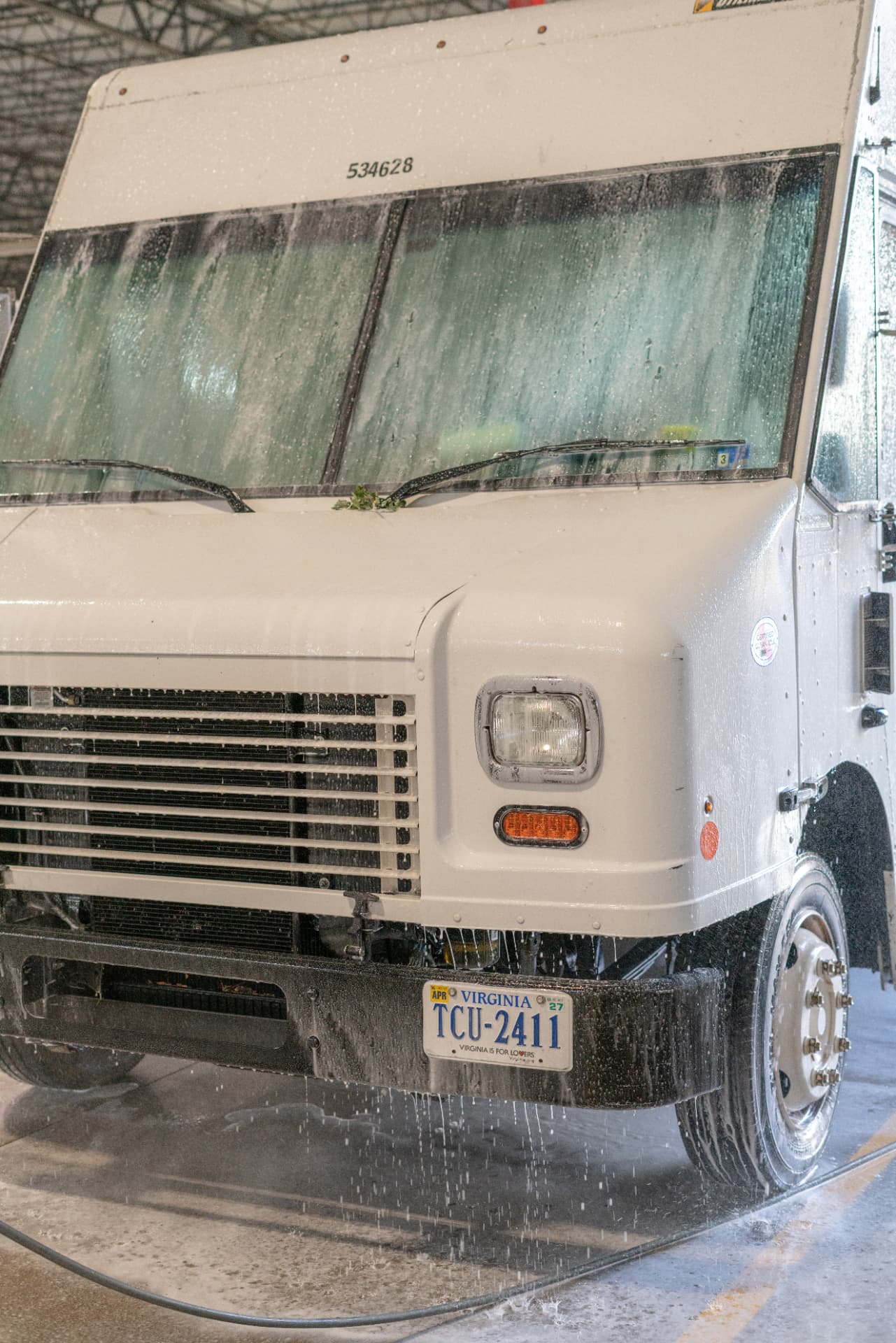 Freshly washed white delivery truck dripping clean water