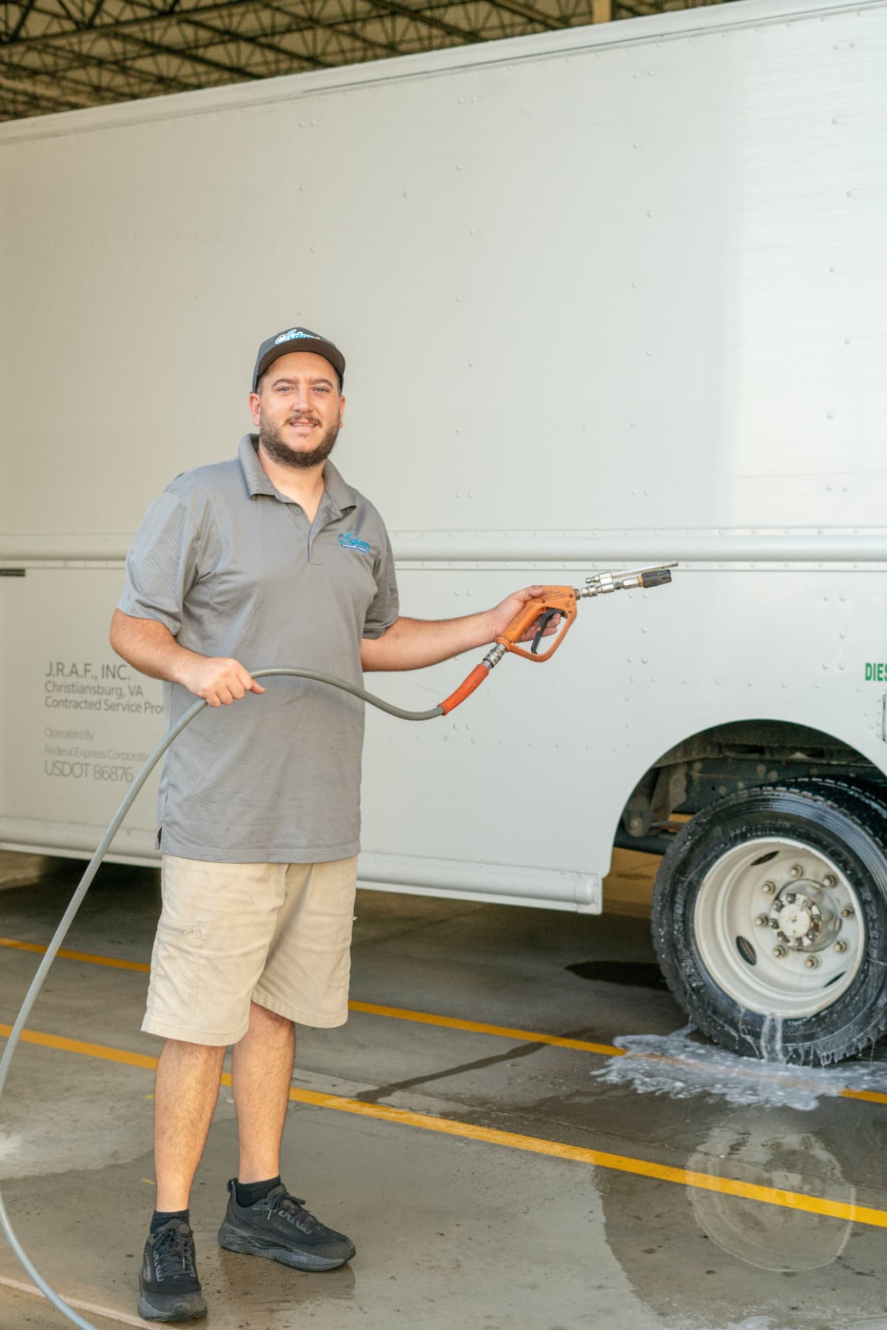 Adam washing a white delivery box truck with a pressure washer